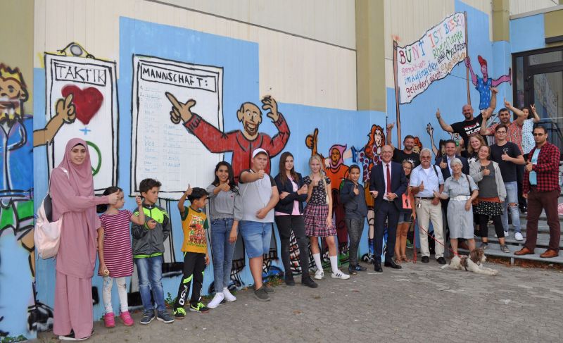 Foto zeigt die Teilnehmer des Graffiti-Projektes zusammen mit Bürgermeister Bert Spilles und dem Ersten Beigeordneten Holger Jung.