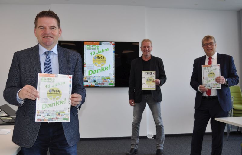 Foto zeigt die drei Initiatoren Bürgermeister Holger Jung, Schulleiter Peter Hauck und Kreishandwerksmeister Thomas Radermacher mit der Jubiläums-Zeitung.