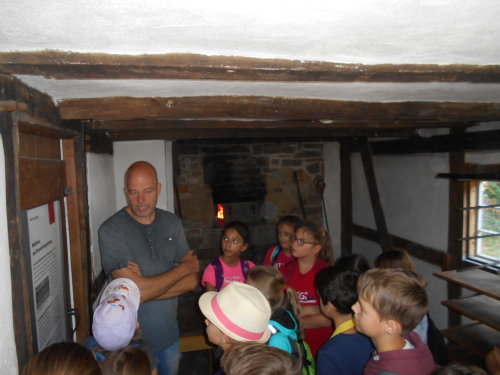 Herr Klug erklärt den Kindern das Backen in der alten Backstube. Foto: KGS