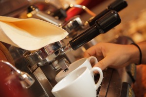 Foto zeigt zwei Tassen, die auf ihre Befüllung durch eine gastronomische Kaffeemaschine warten
