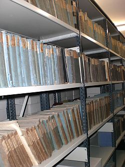Das Bild zeigt ein mit Archivgut gefülltes Regal im Stadtarchiv