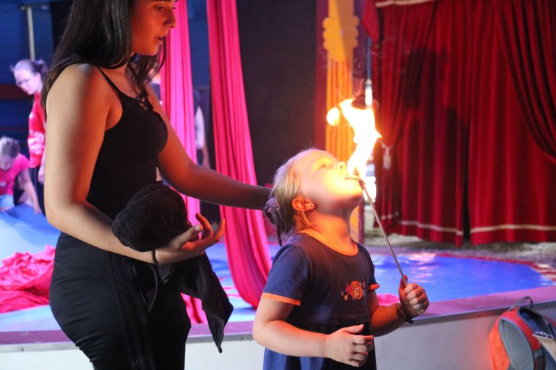 Foto zeigt eine Betreuerin und eine Teilnehmerin der Zirkuswoche beim Feuerspucken.