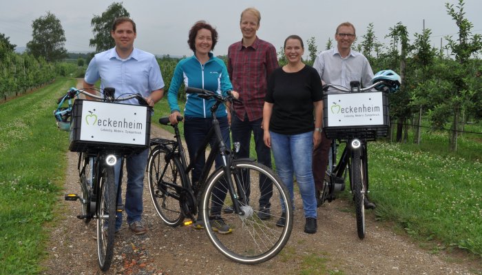 Foto zeigt Vertreter der Stadt Meckenheim und Wirtschaftsförderung sowie des Rhein-Voreifel Touristik e.V. mit Pedelecs in den Obstplantagen.